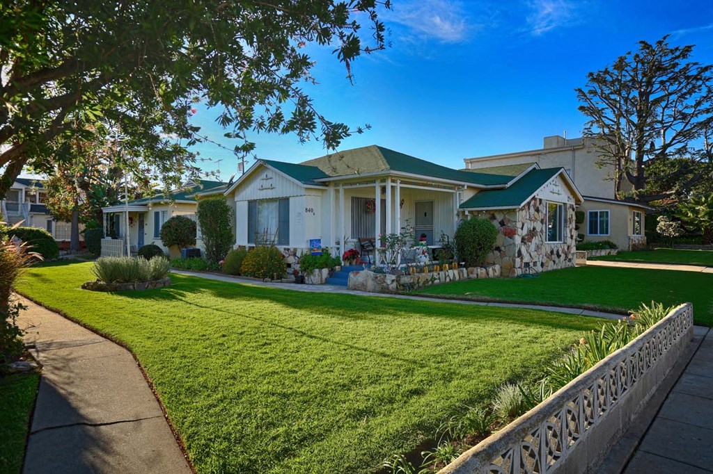 a house with a lawn and a fence in front of it