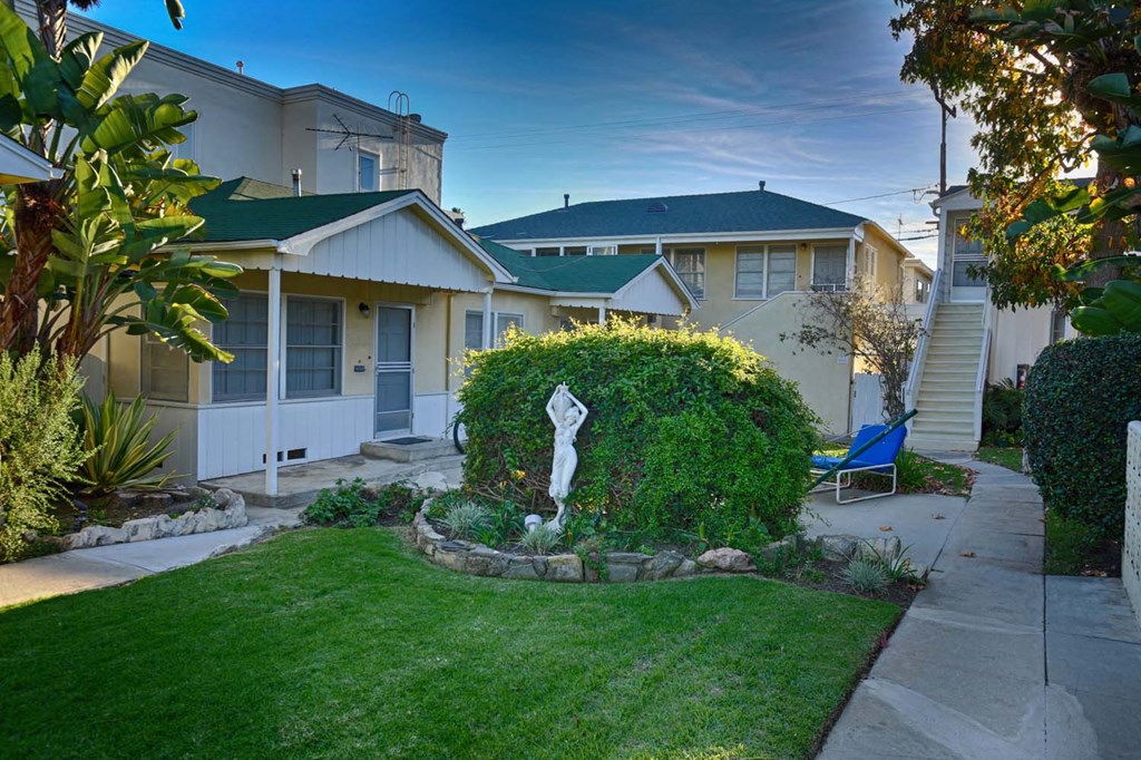 a yard with green grass and a white statue in the middle