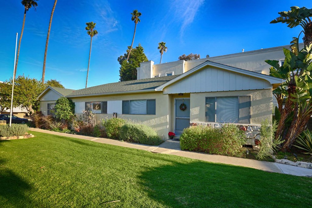 a house with a lawn and a sidewalk in front of it