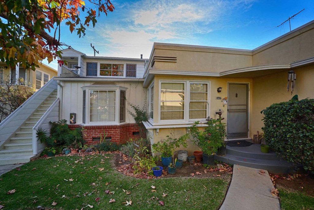 the front of a house with a yard and stairs