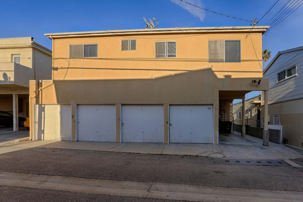 a building with three garage doors and a street in front of it