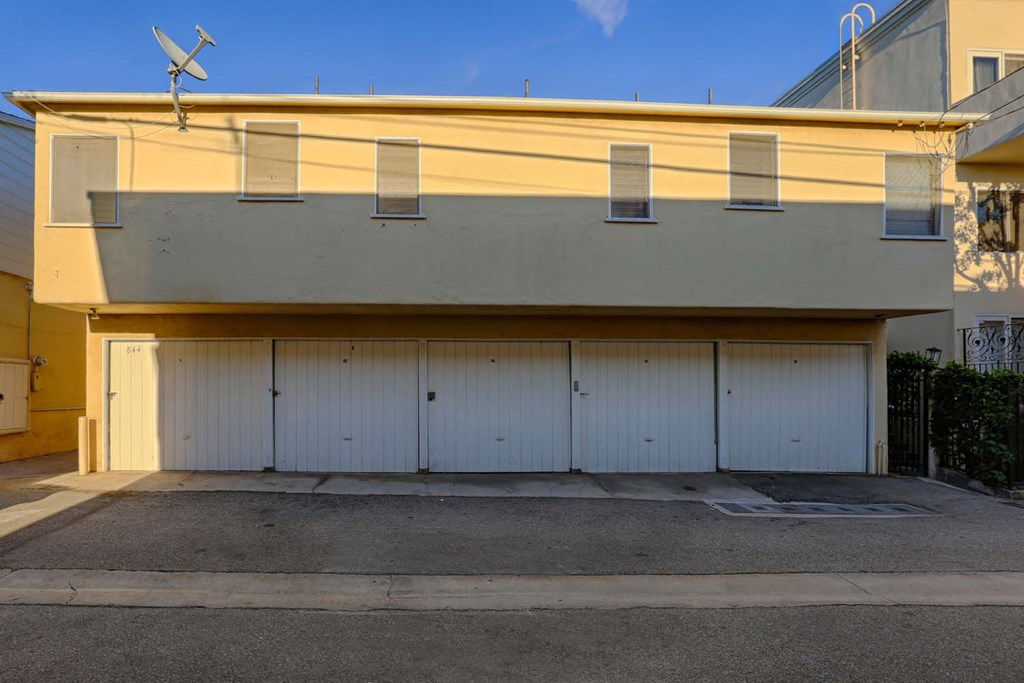 a white garage door in front of a yellow house