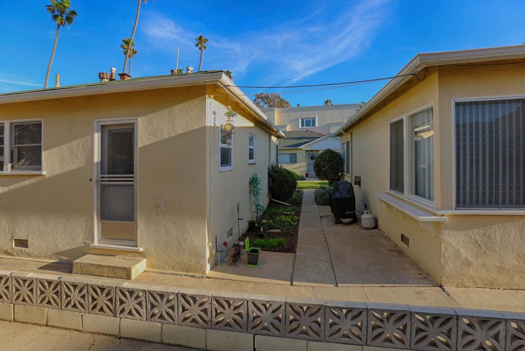 a view of two houses from the sidewalk