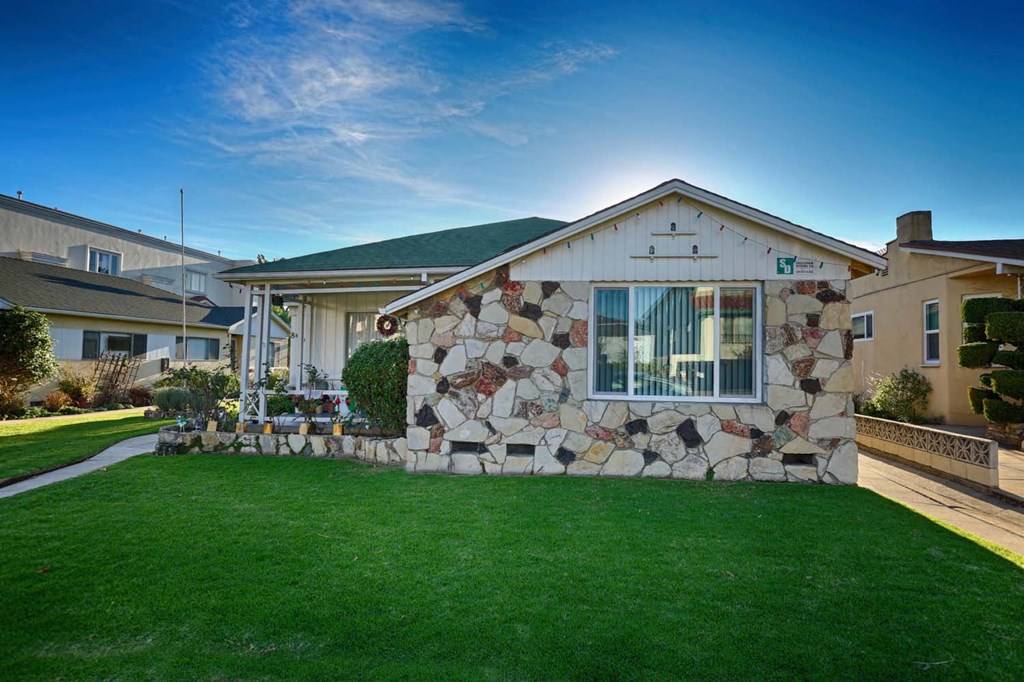 a stone house with green grass and a lawn