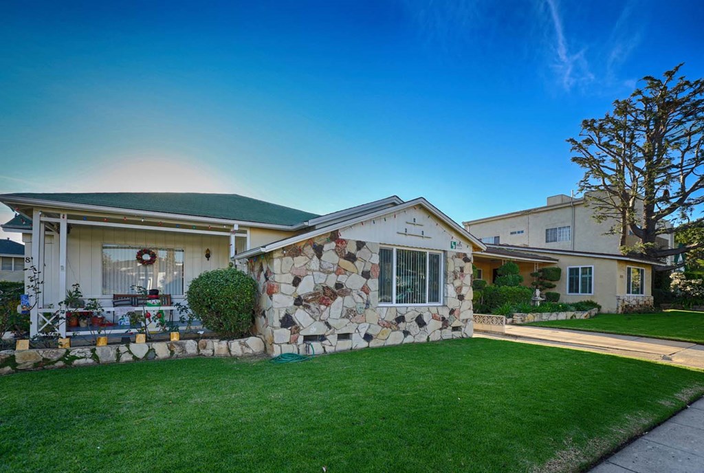 a home with a stone facade and green lawn