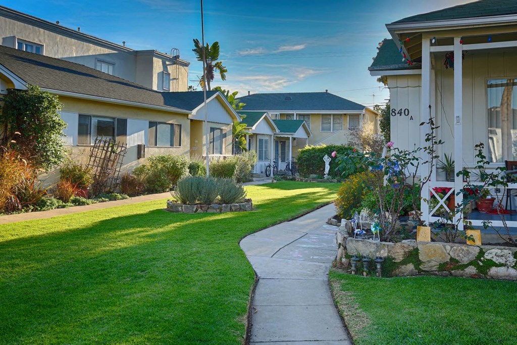 a sidewalk in front of a row of houses
