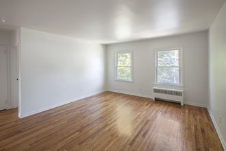an empty living room with white walls and wood floors