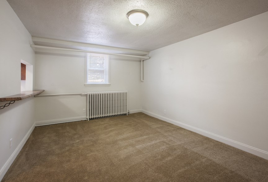 an empty room with a radiator and a window