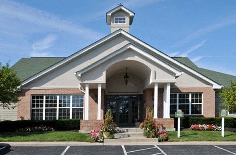 the front of a church building with a lawn and flowers