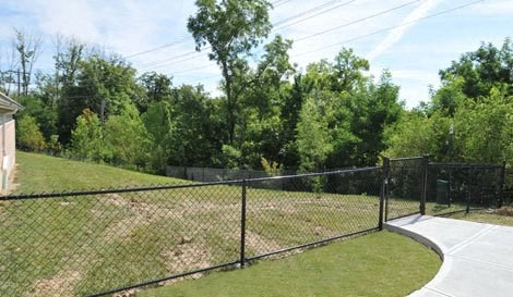 a chain link fence around a tennis court in a yard