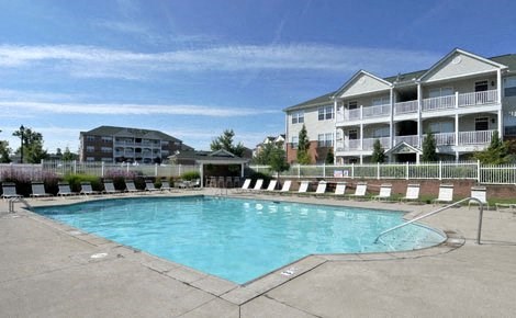 a large swimming pool in front of an apartment building
