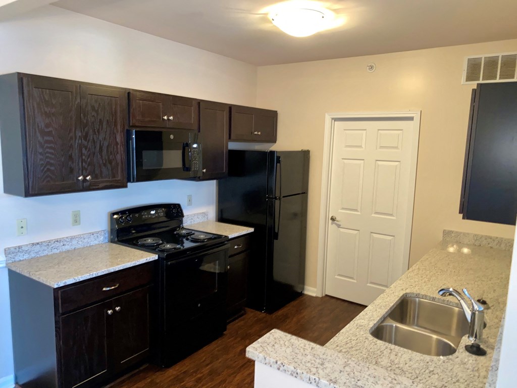 a kitchen with black appliances and granite counter tops