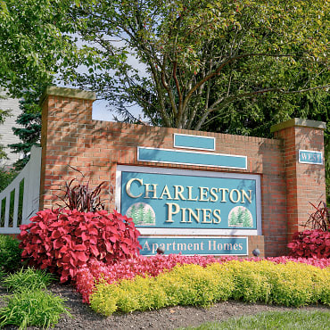 a sign pines apartment homes in front of a brick wall