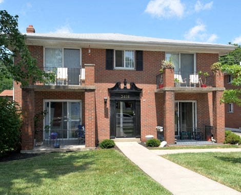 a brick house with a sidewalk in front of it