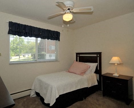 a bedroom with a bed and a ceiling fan