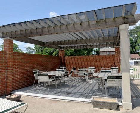 a patio with tables and chairs under a roof