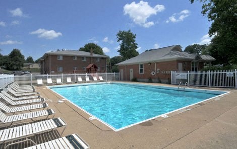 a swimming pool with white chairs around it