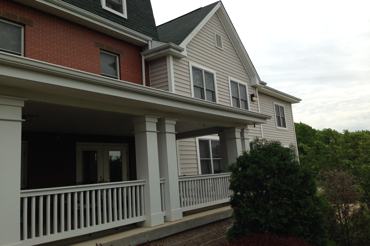the front of a house with a wrap around porch