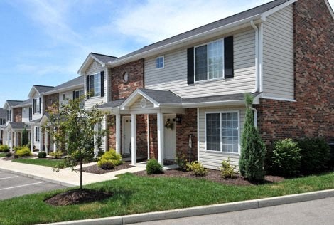 a row of houses with brick and white siding