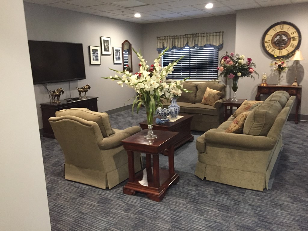 a living room with couches and a table with flowers