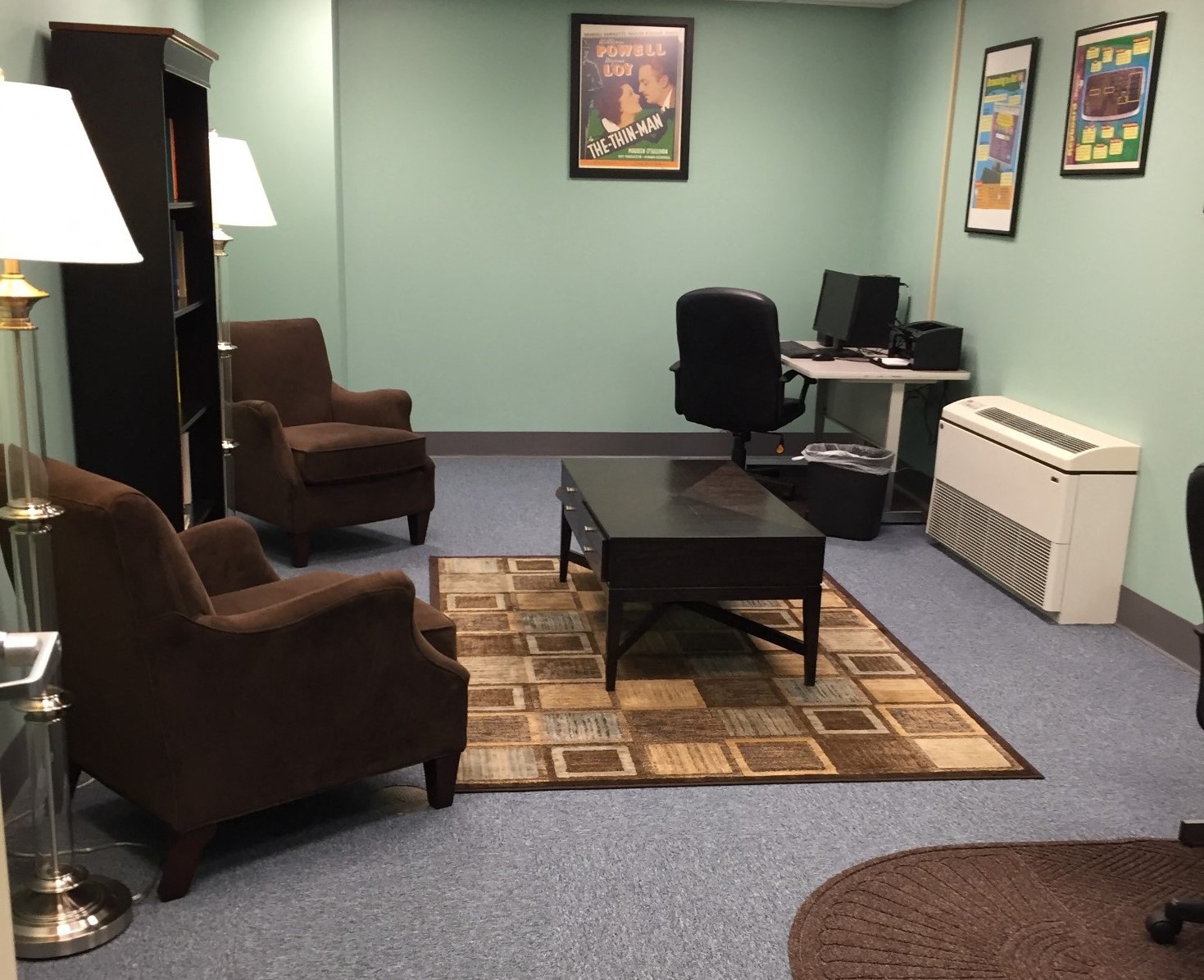a living room with chairs and a table and a computer