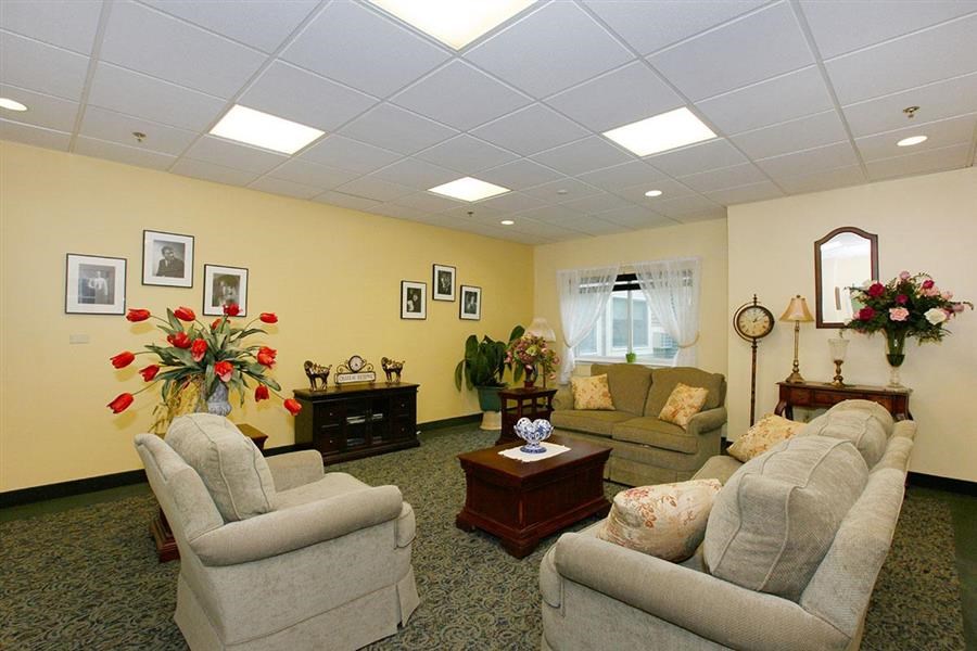 a living room with couches and chairs and a clock
