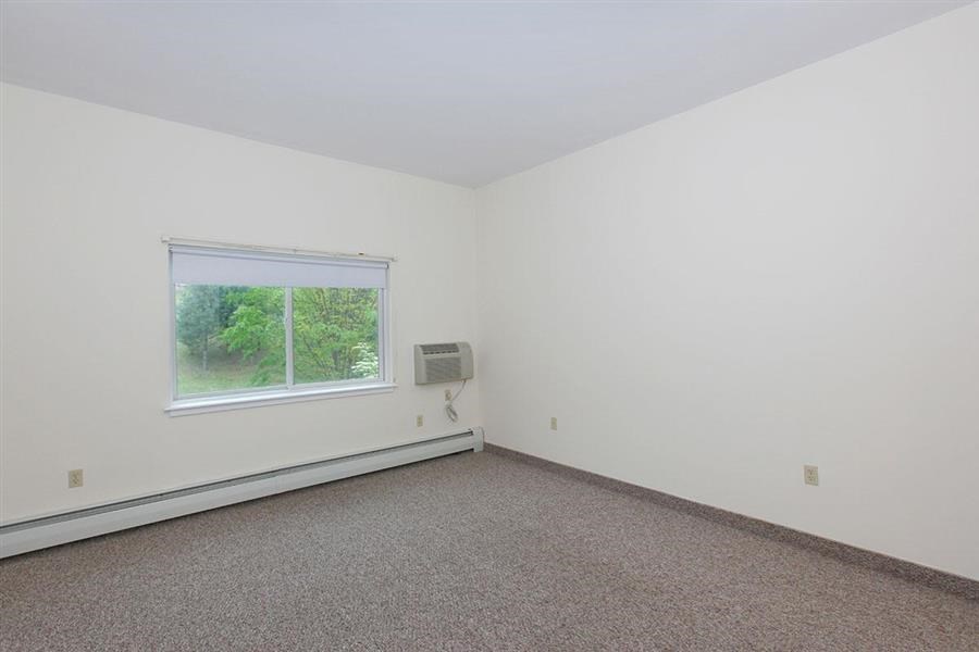 an empty room with a window and carpet