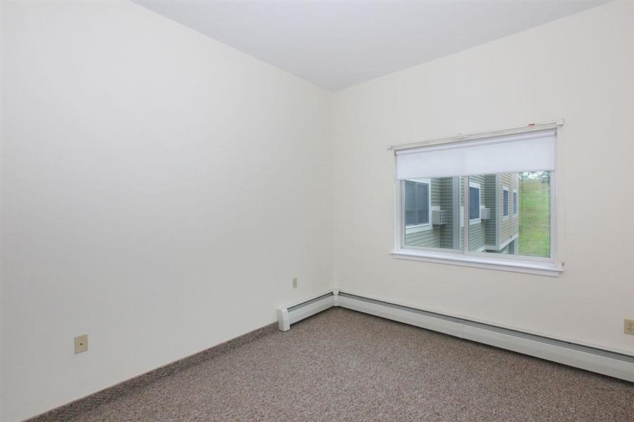 an empty room with a window and a carpet