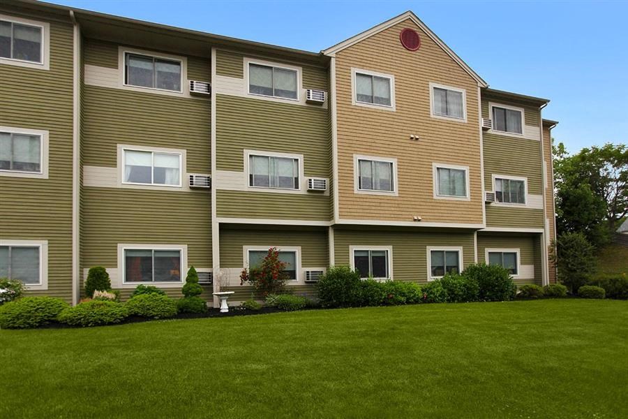 a large apartment building with green grass in front of it