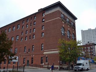 a large red brick building with a white truck parked in front