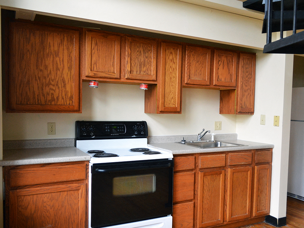 a kitchen with wooden cabinets and a stove and a sink