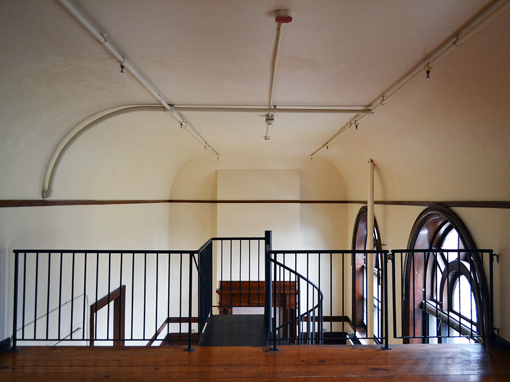 the inside of a church with a staircase and a bench