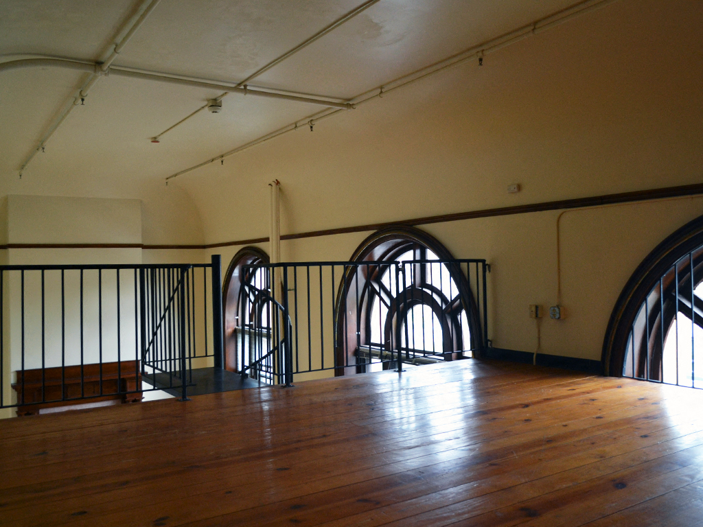 the inside of a large room with a wooden floor and iron gates