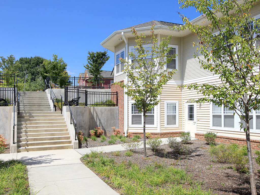 a house with stairs and a sidewalk in front of it