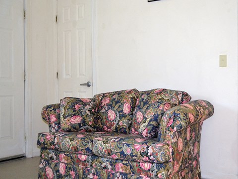 a floral couch in a living room with a white door