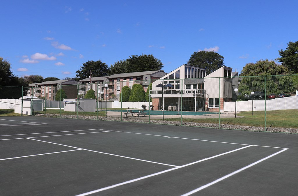 a tennis court with apartments in the background