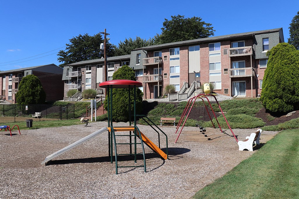 an empty playground in front of an apartment building