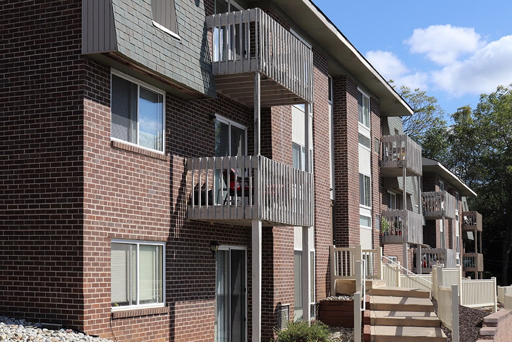 a brick apartment building with balconies and stairs