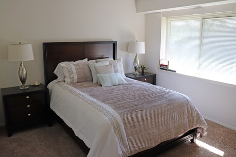 a bedroom with a bed and two night stands and a window