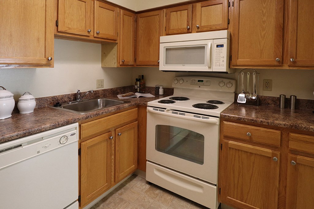 a kitchen with white appliances and wooden cabinets