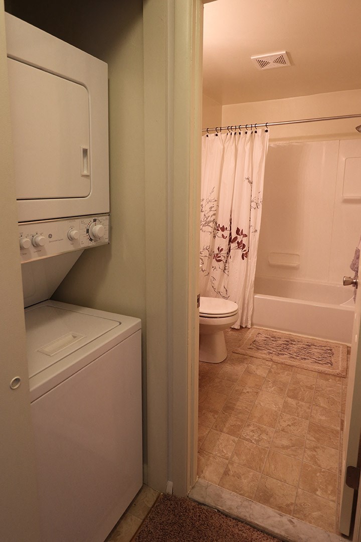 a bathroom with a toilet and a washer and dryer in it
