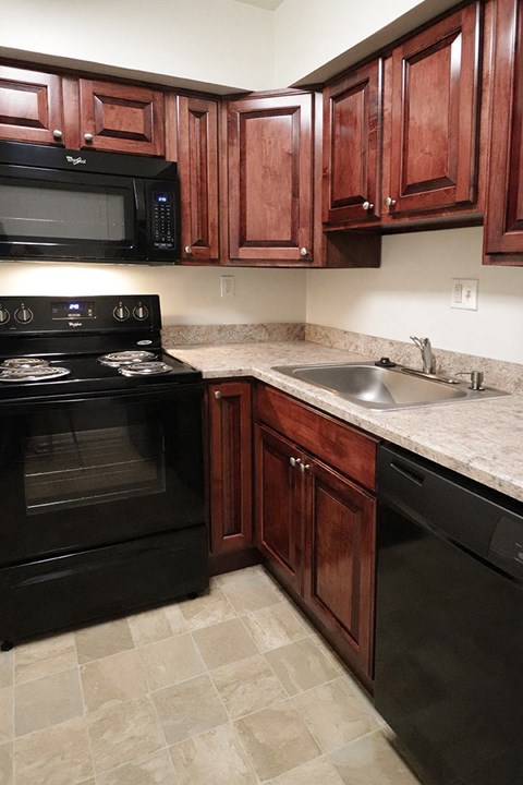 a kitchen with black appliances and wooden cabinets