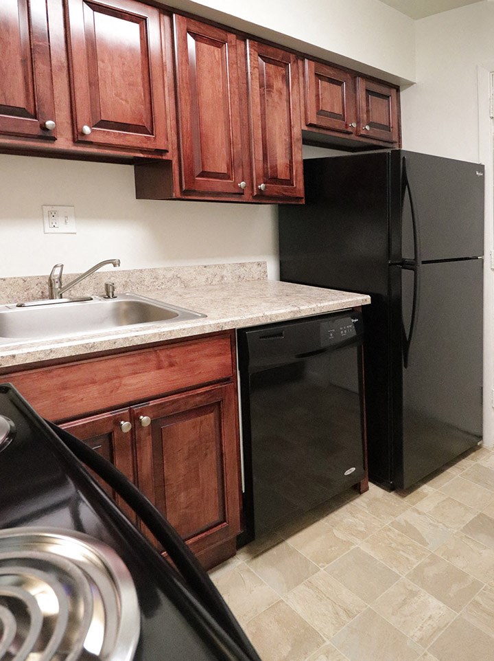 a kitchen with black appliances and wooden cabinets