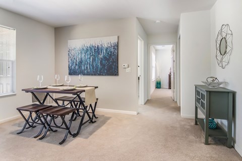 A dining room with a table and chairs.