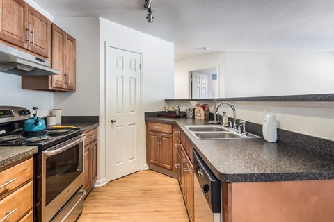 A kitchen with wooden cabinets and black countertops.