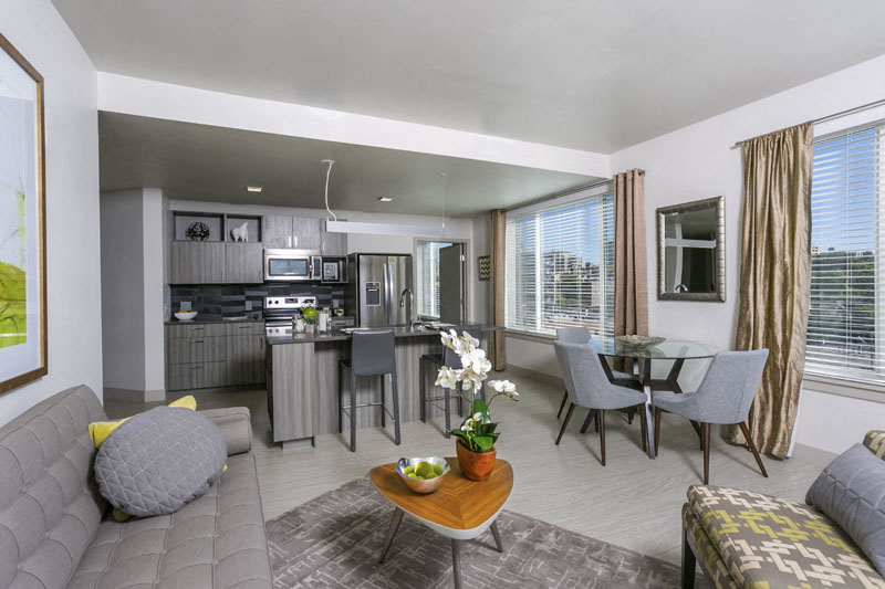 a living room with a couch and a table and a kitchen