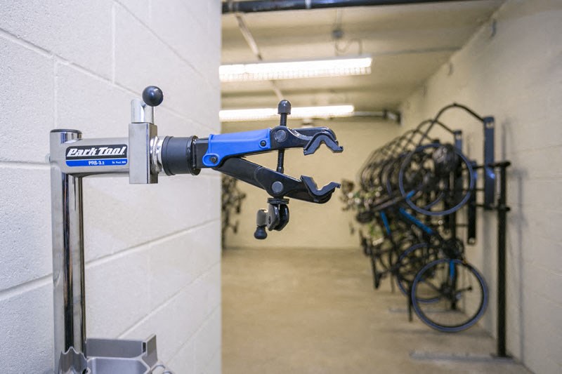 a bunch of bikes are hanging on a wall in a room
