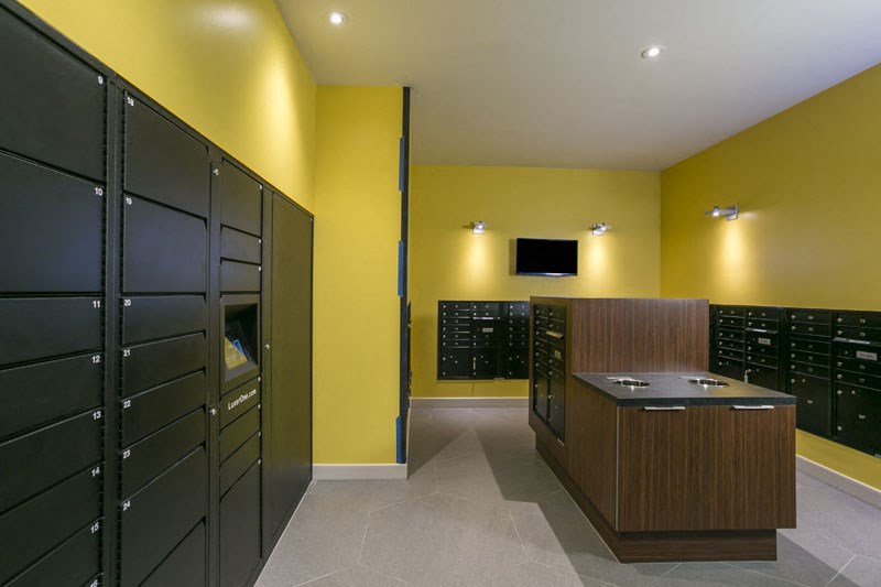 a large room with yellow walls and lockers and a desk