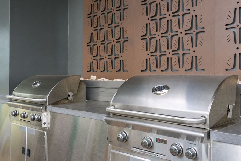 two stainless steel gas grills in a kitchen