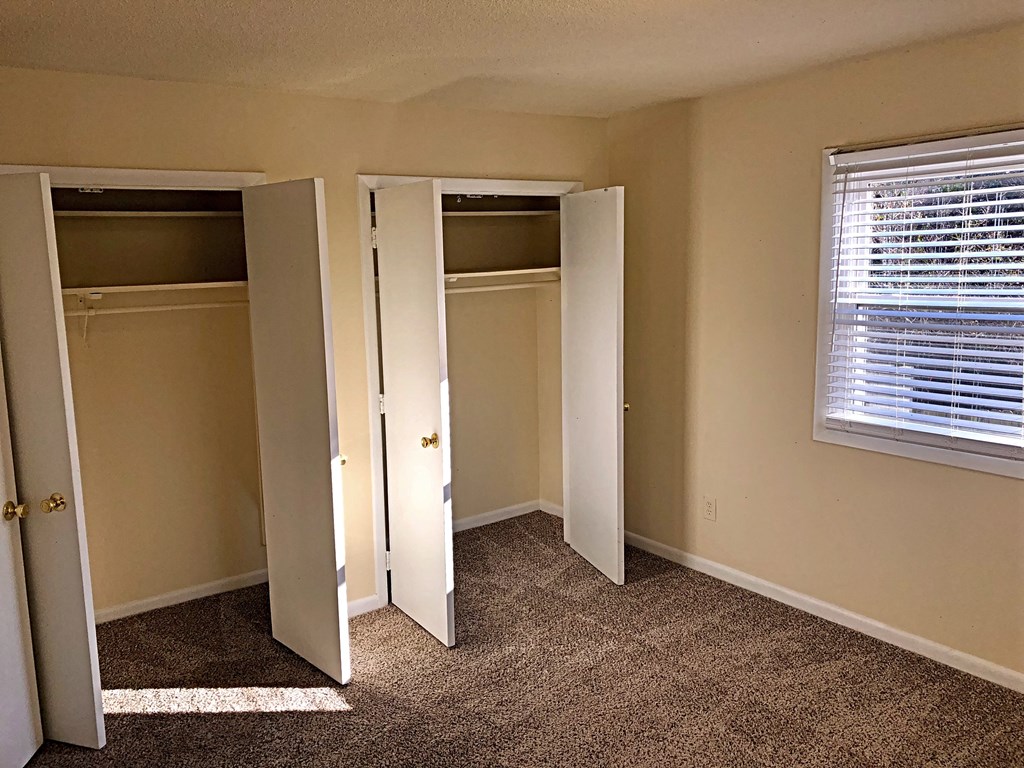 a bedroom with three closets and a window